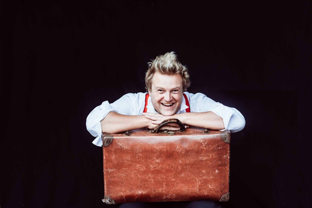 Image of an entertainer in from of black backdrop