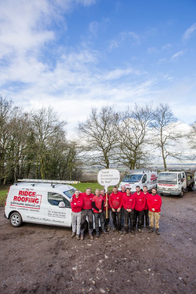 Roofing team by a van